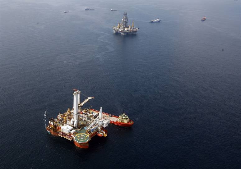 Helix Q4000 (dole) ucpal cementem po�kozený vrt. Naho�e vrtná plo�ina Driller III, která hloubila pomocný vrt